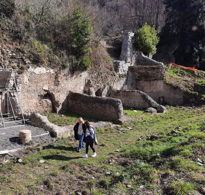 Two women walking around the Roman ruins of the Temple of Goddess Diana